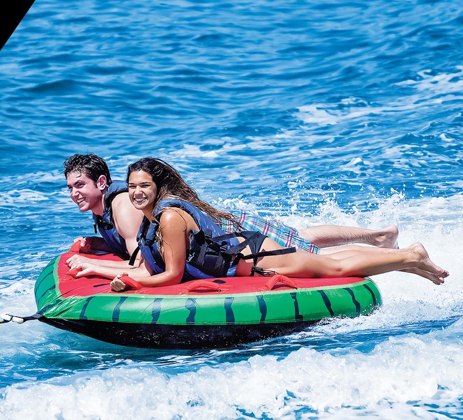people riding watermelon raft