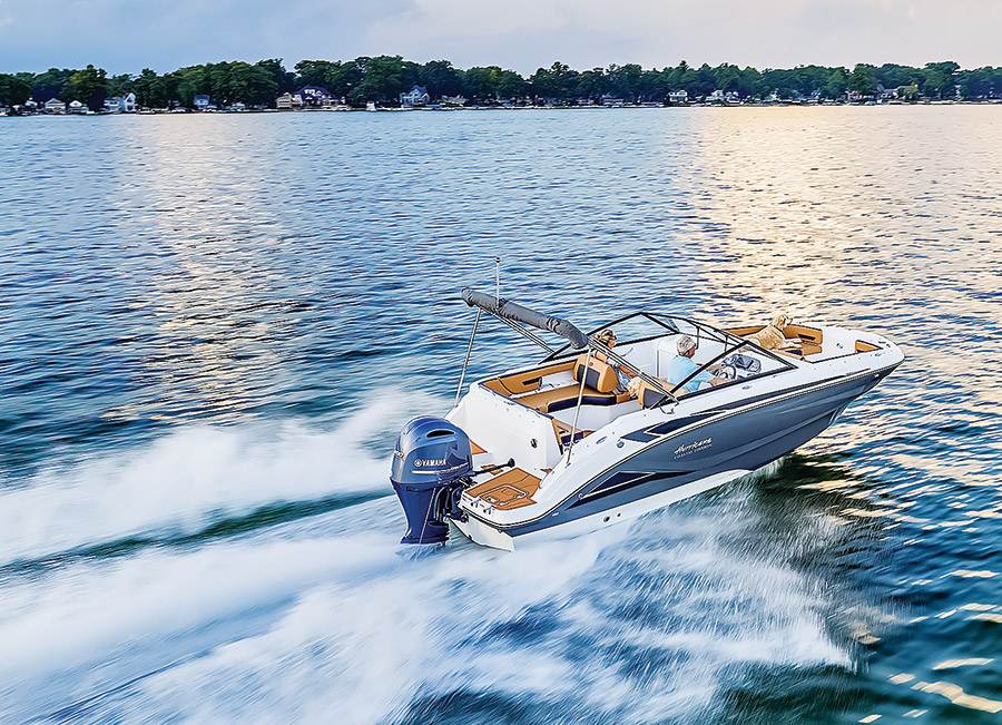 SunDeck 235-OB driving off with the sun glistening on the water