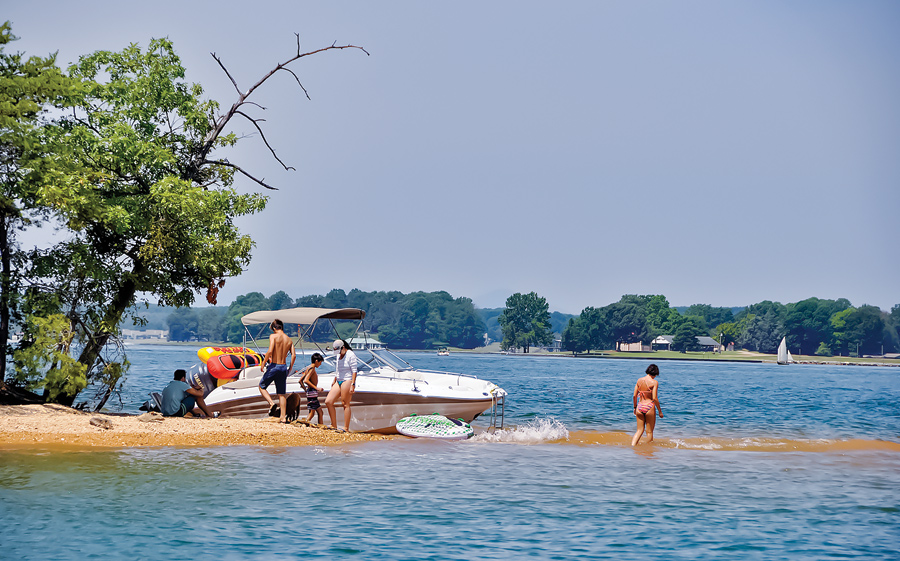 boat and group of people on shore of small island in the lake