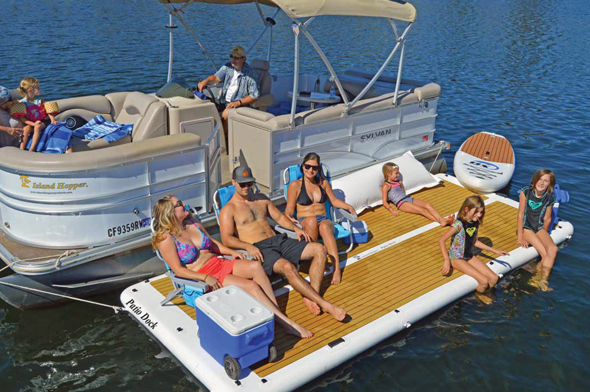 a family of six relaxes on a patio dock connected to a pontoon