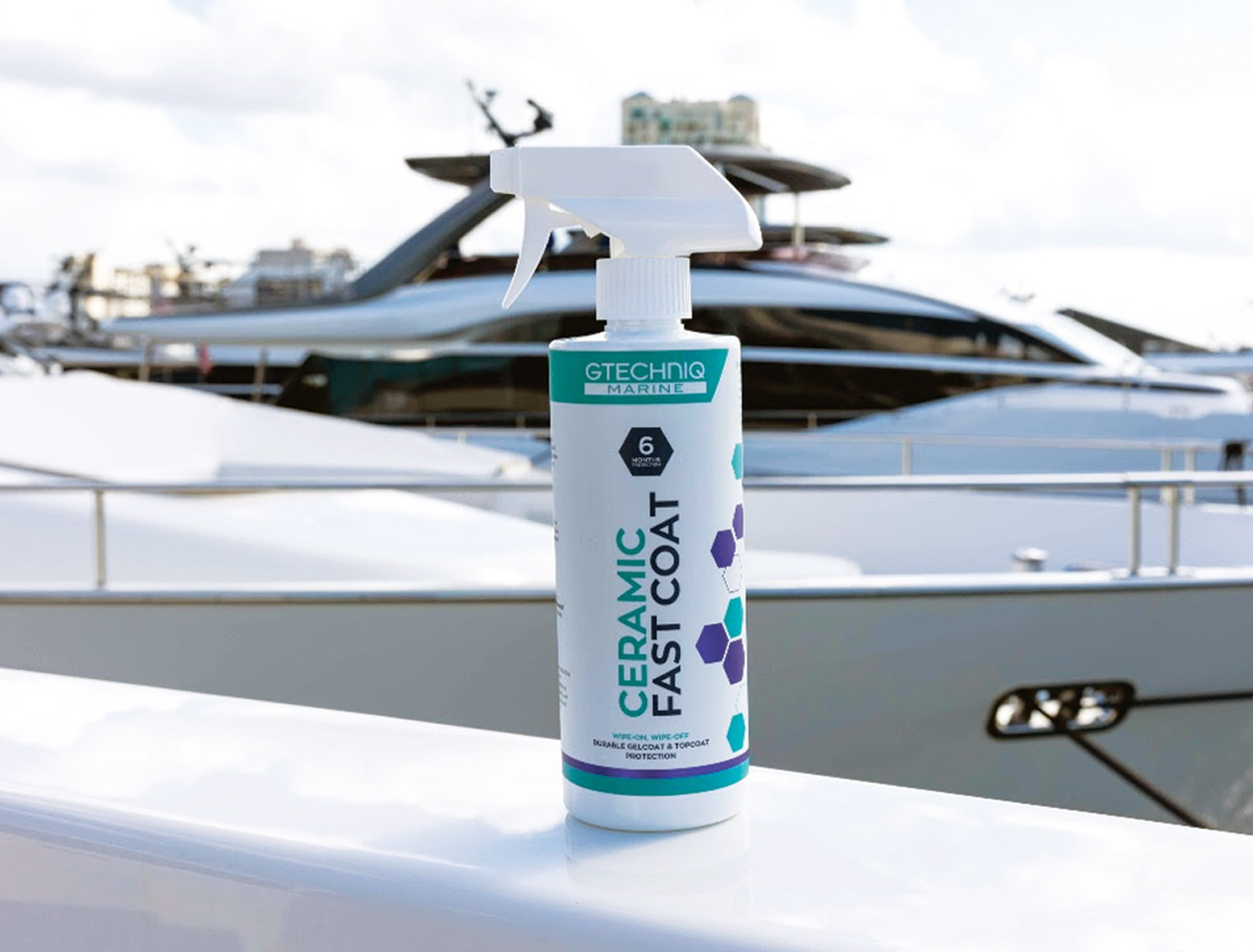 Gtechniq a container of Marine Ceramic Fast Coat sits on the deck of a boat with another boat in the background