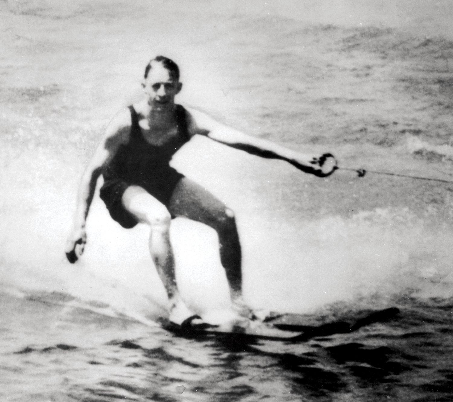 an old black and white photo of a man water skiing