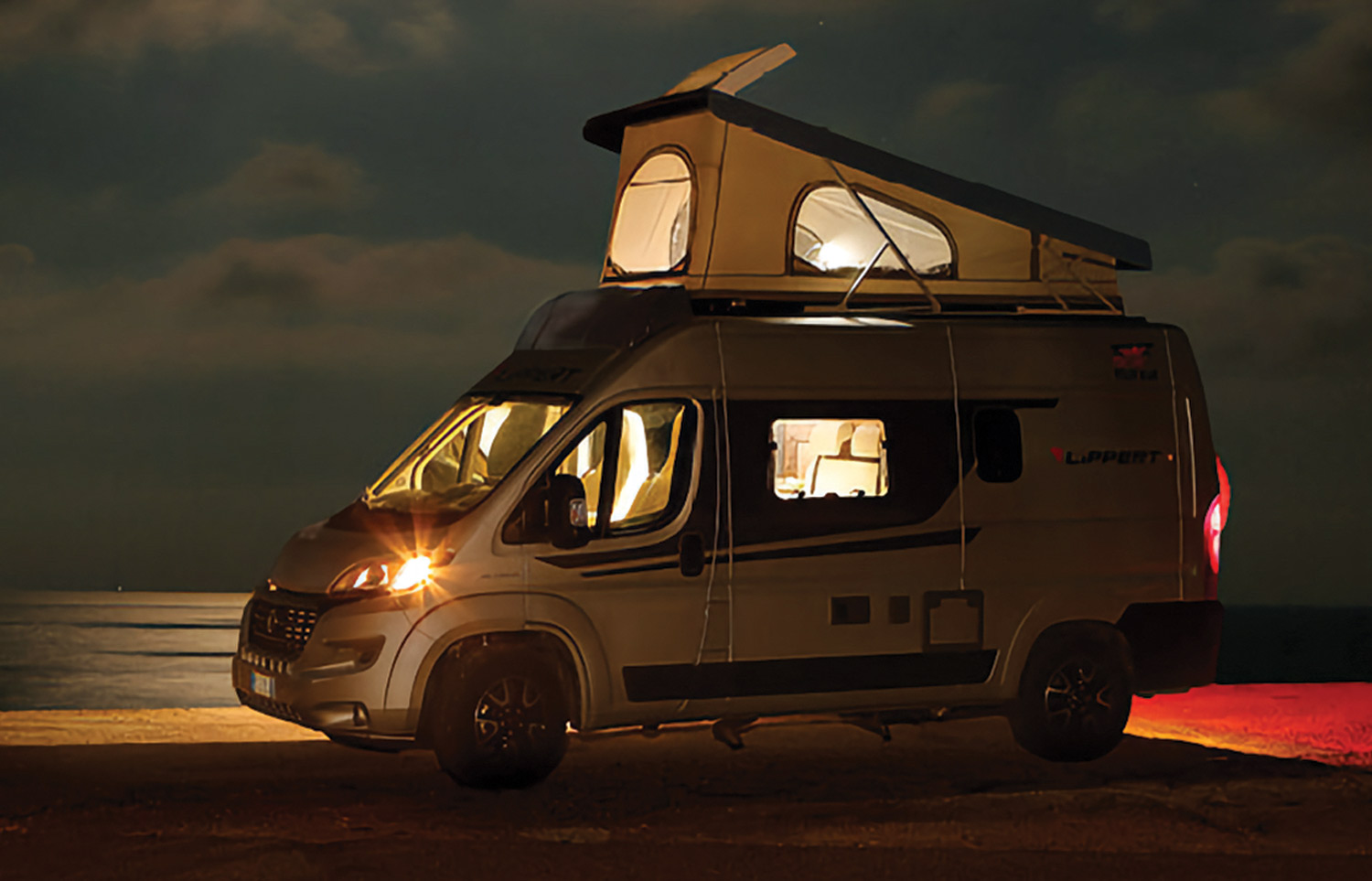 a utility van with a tent set up on its roof