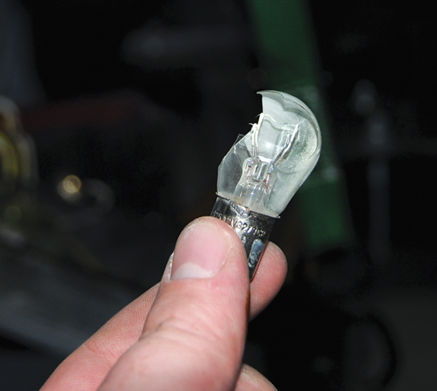close view of a hand holding a broken light bulb