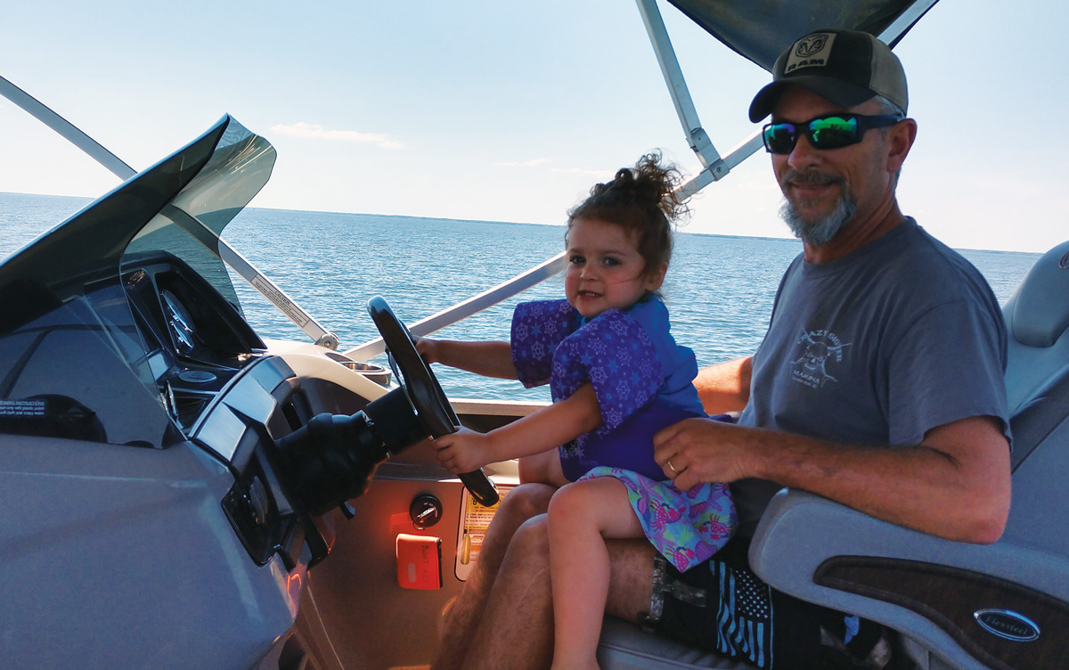JD Wilson with his granddaughter driving the boat