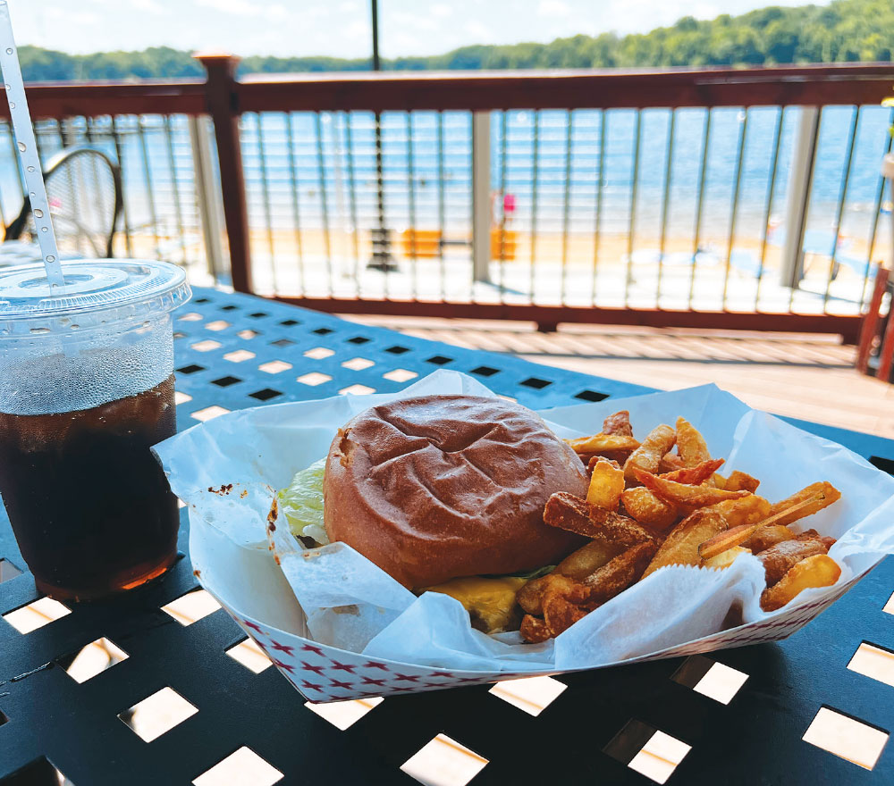 burger with fries and drink by dock