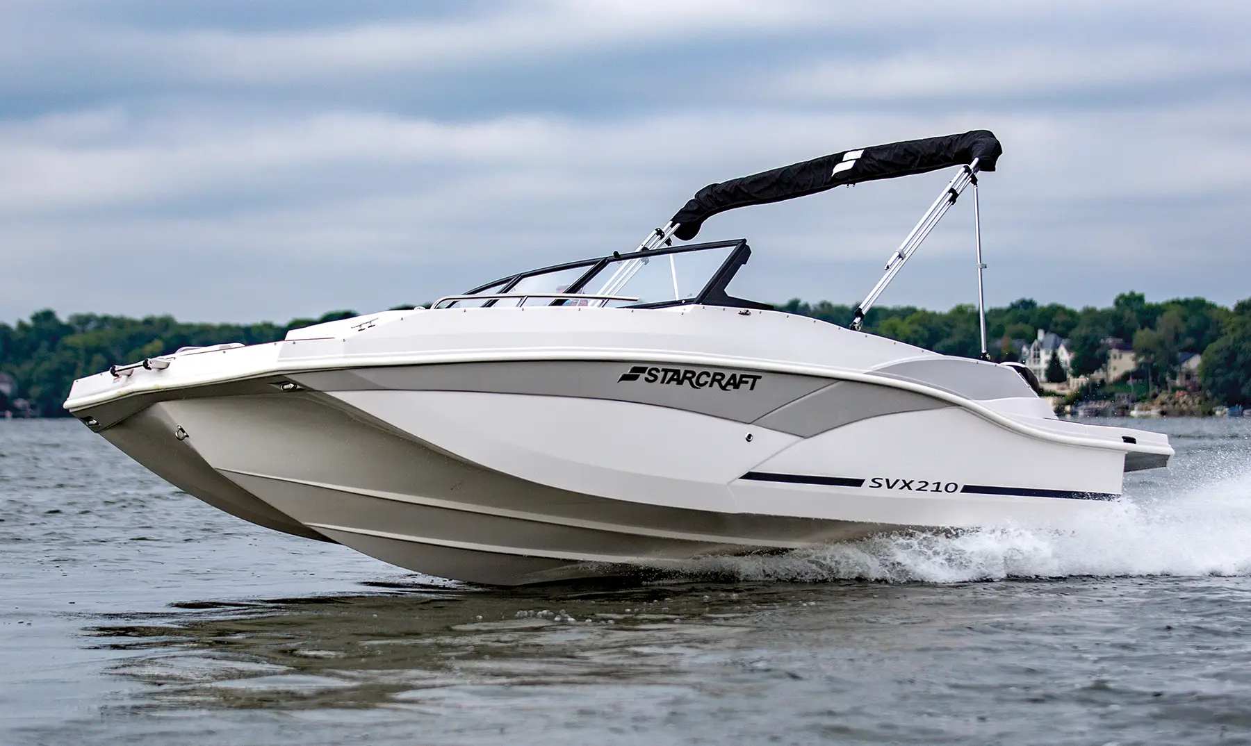 Profile view of Starcraft SVX in motion on water with blue sky and clouds