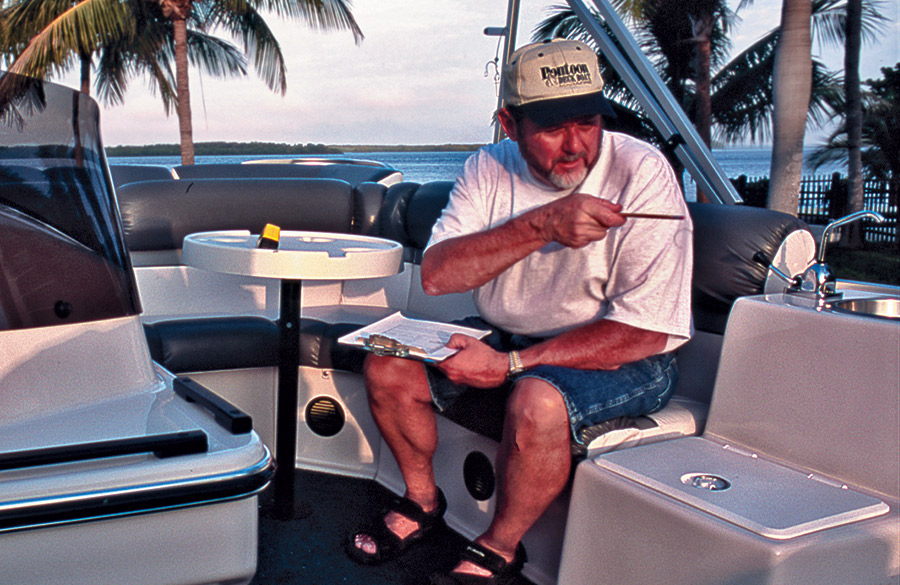 Man sitting on a boat with the ocean and palm trees in the distance