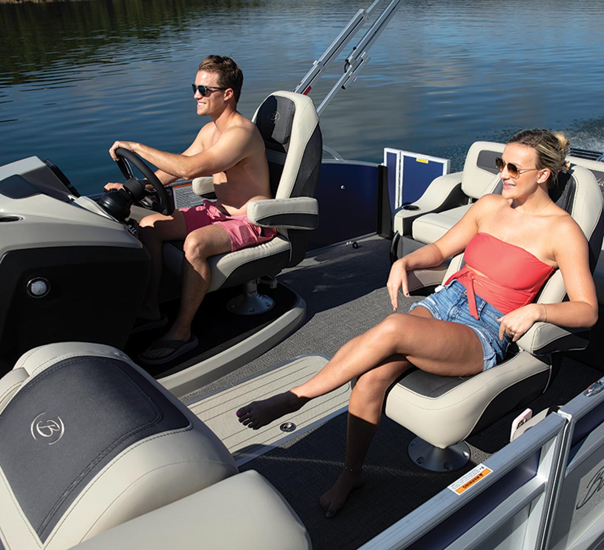 a man steers the Barletta Cabrio 22UC while a women relaxes in the front passenger seat