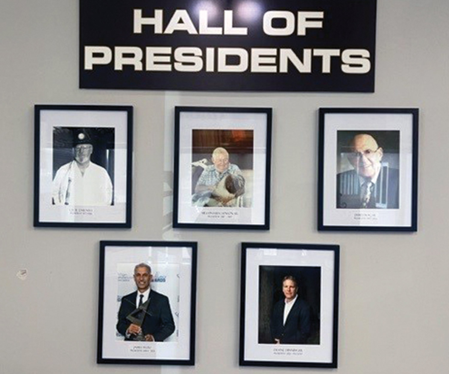 a wall with the sign "Hall of Presidents" and five frames hanging below