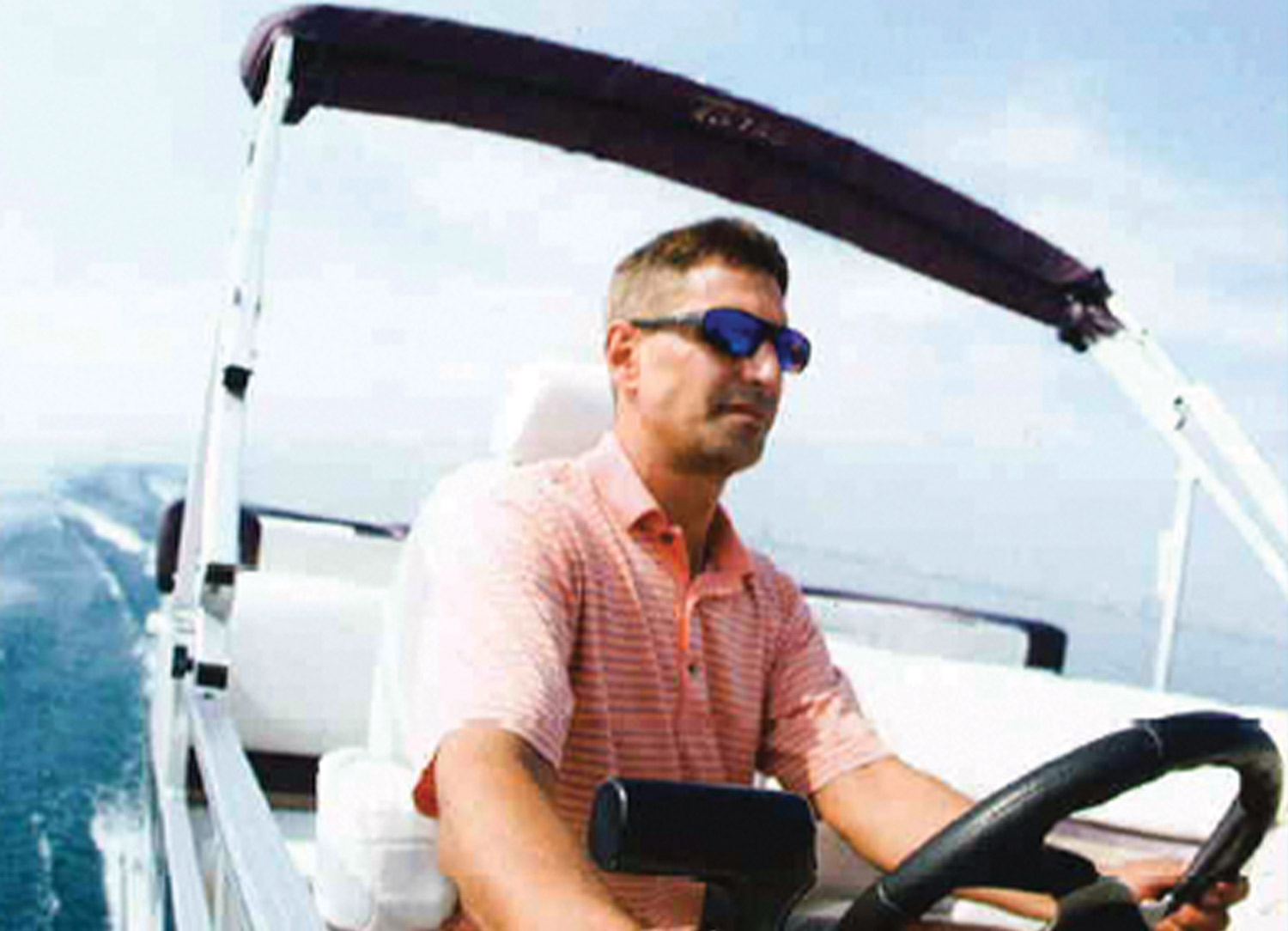 dashboard camera image of a man at the wheel of a pontoon while driving