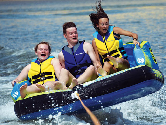 Three kids riding on the Obrien Baller 3 towable