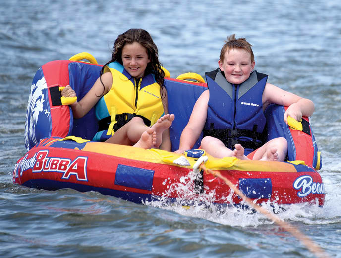 Two kids riding in Wow Beach Bubba towable