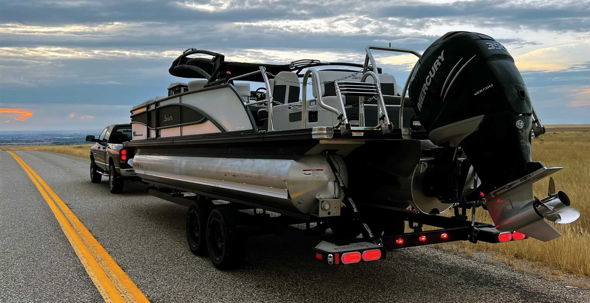 a boat behind a truck on the open road