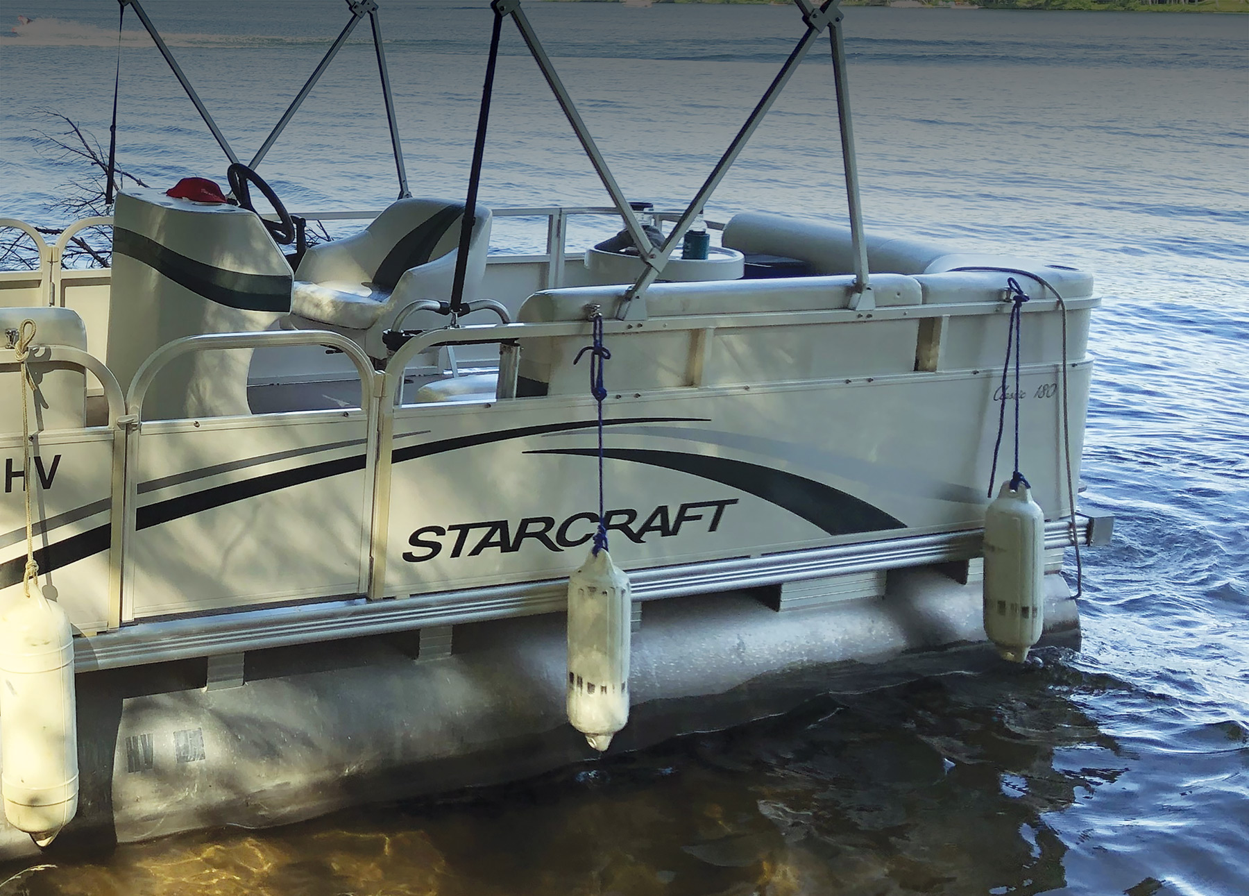 Side view of Starcraft Marine Classic 180 boat fenders hanging docked at sea during the day