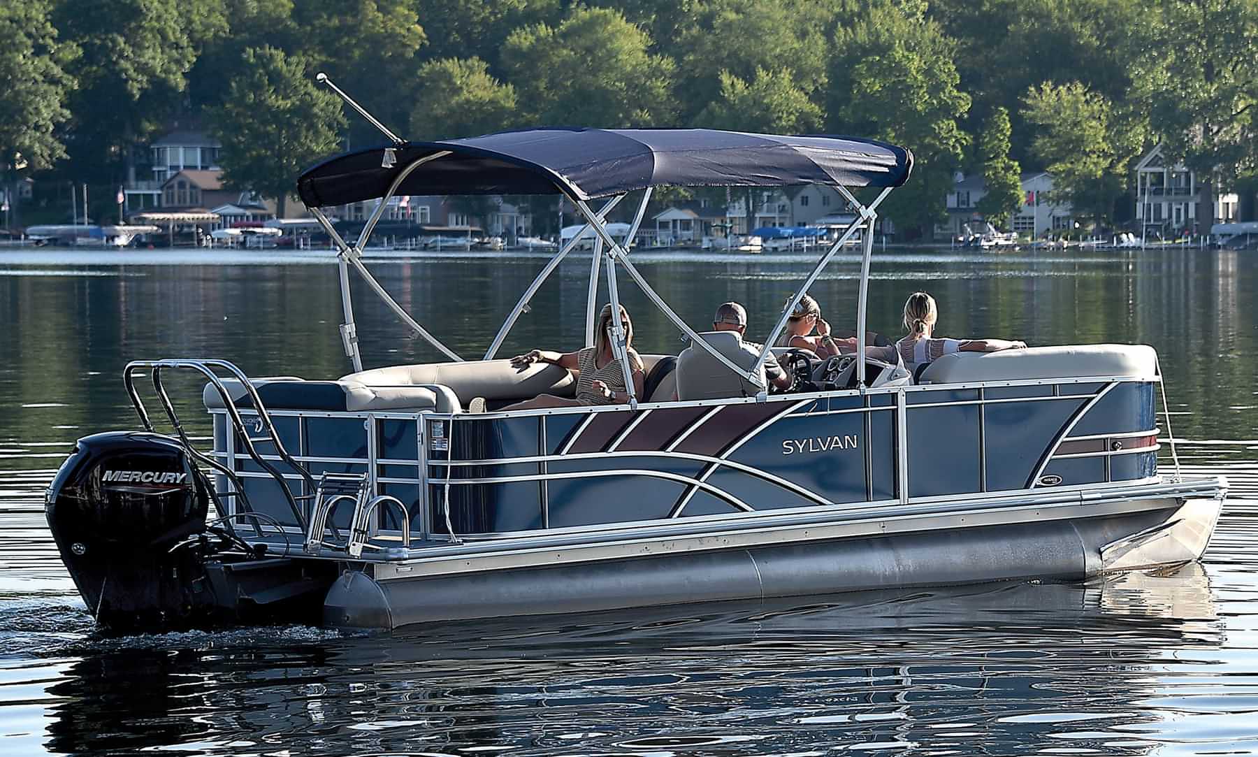 distant view of three women and a man relaxing on a Sylvan pontoon on water