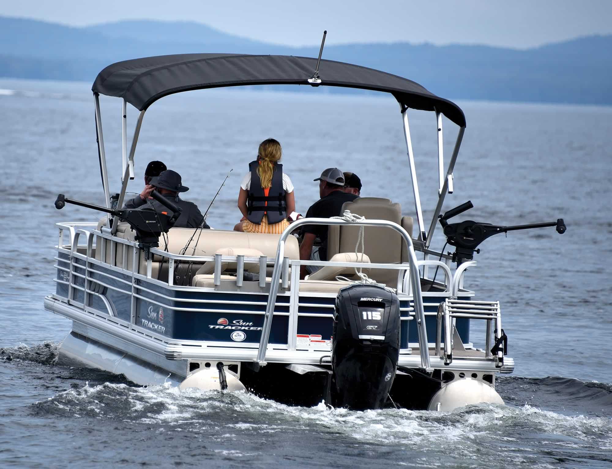 back view of four men and a young girl sailing on a Sun Tracker pontoon