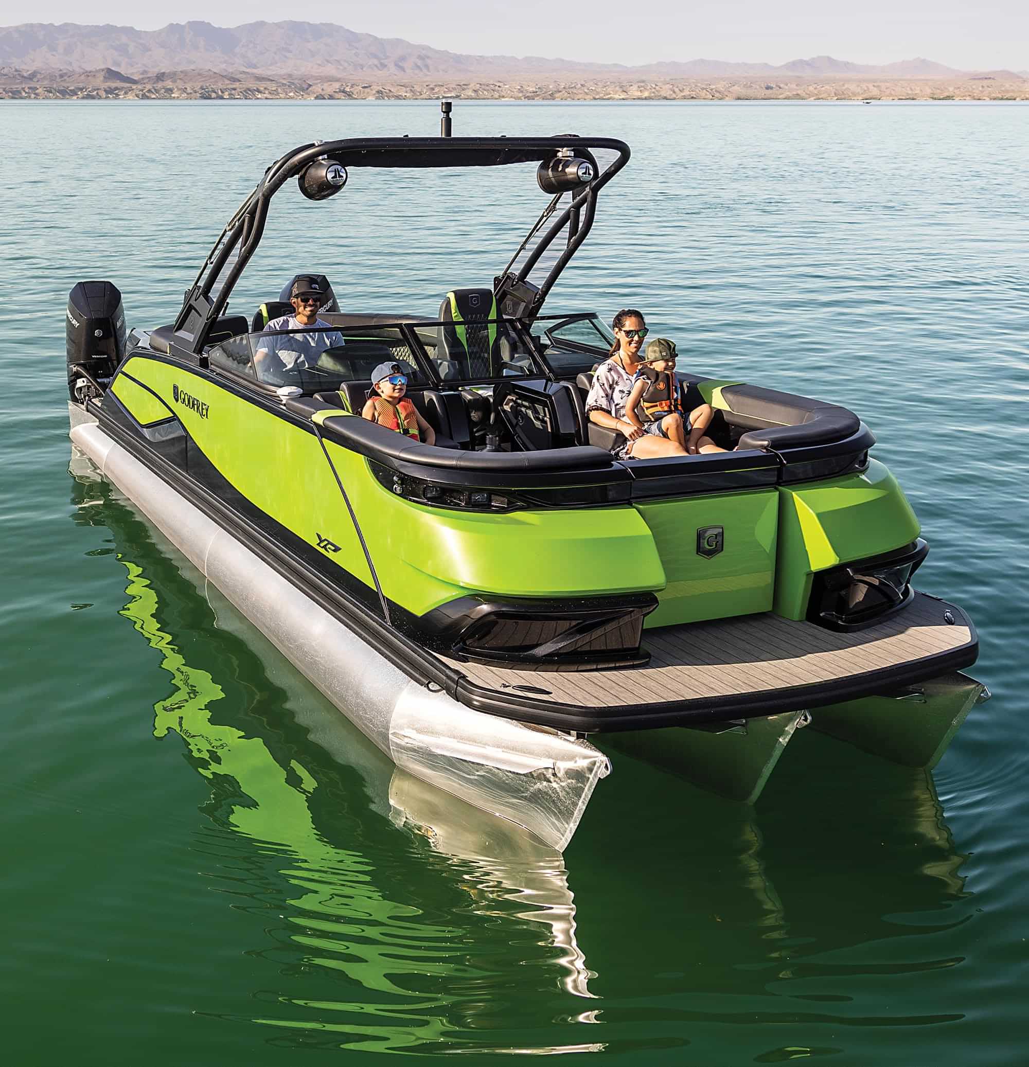 front view of a family of four enjoying a lime green Godfrey XP series pontoon on the water
