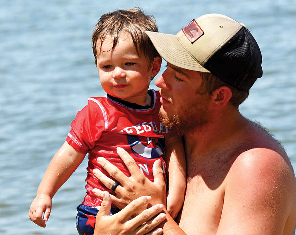Dad holding his young son in the water