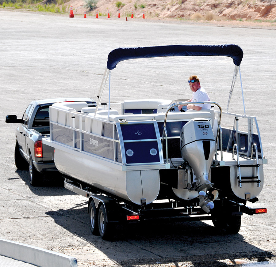 A boat hooked on a back of a truck