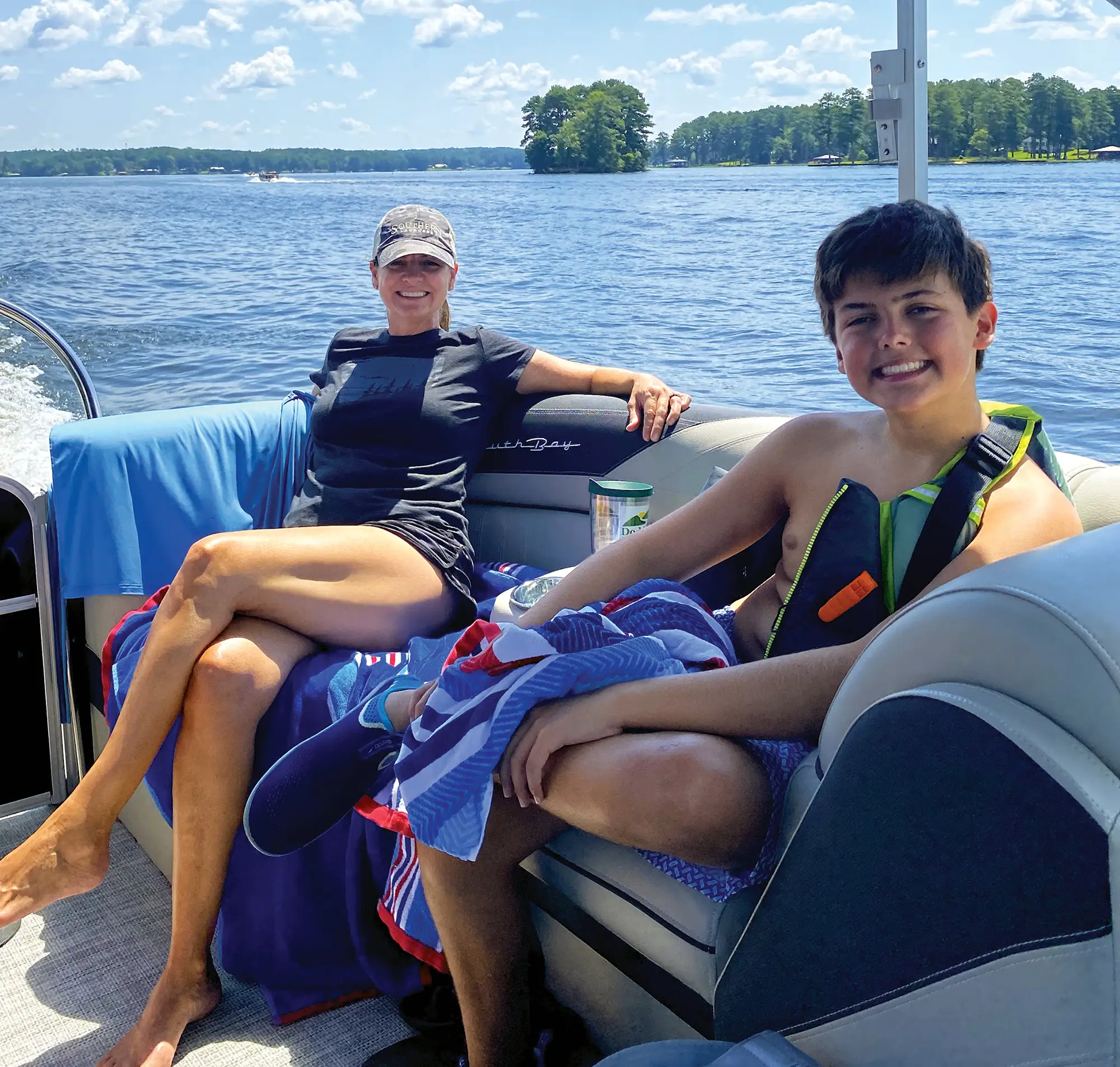 mother and son smiling at the camera on their pontoon