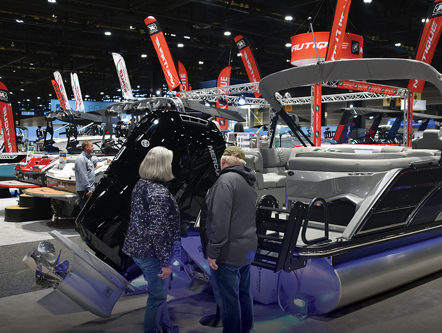 man and woman looking at rear of boat during boat show in show room warehouse
