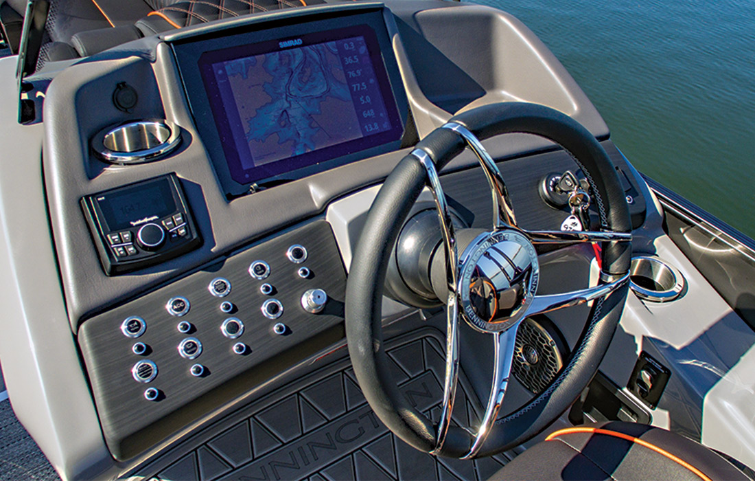 Close up of the steering wheel and the screen and knobs above the wheel