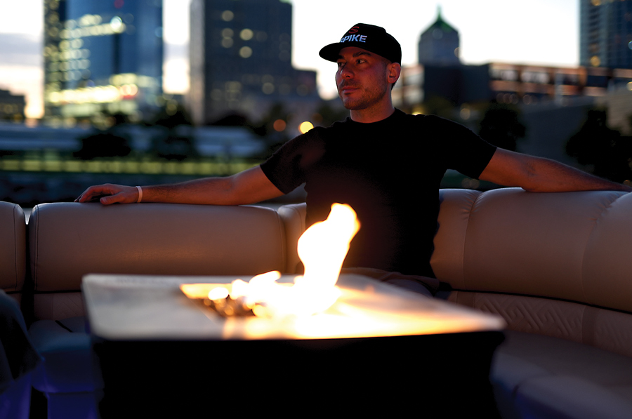 Man sitting on a couch on a pontoon with a fire put in front of him