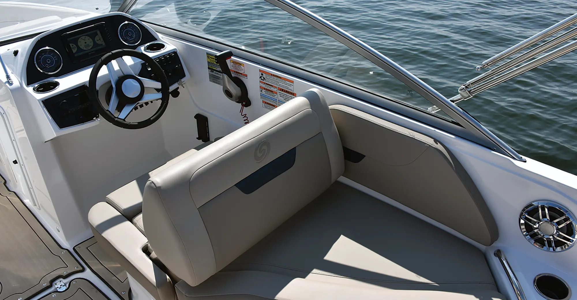 Aerial interior angle photo view of the driver's seat area plus a lounge couch behind the driver's seat of the Hurricane SunDeck 235 pontoon motorboat vehicle