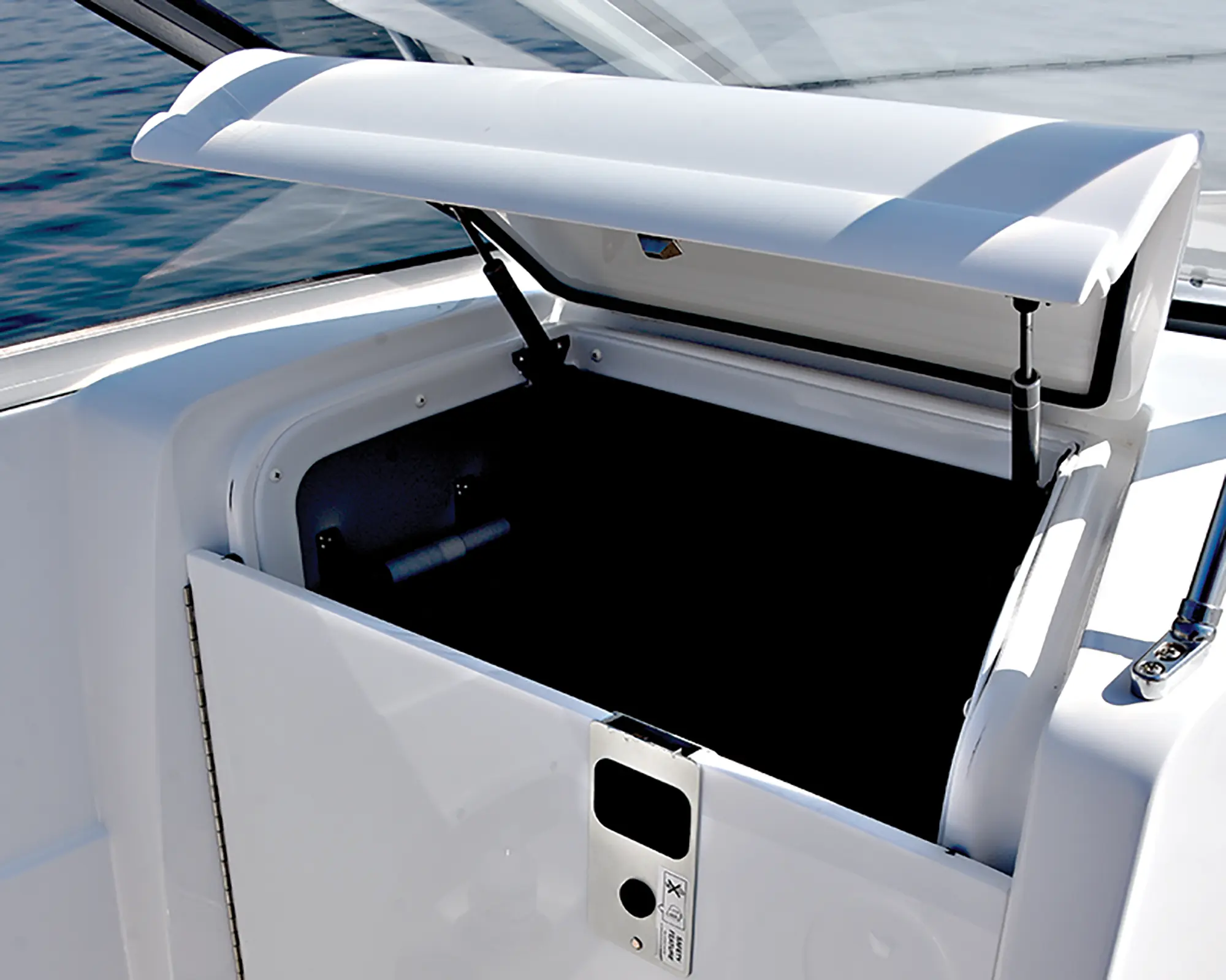 Close-up interior angle photo view of a storage space area with a door flap open in the air with plenty of room inside the storage space of the Hurricane SunDeck 235 pontoon motorboat vehicle