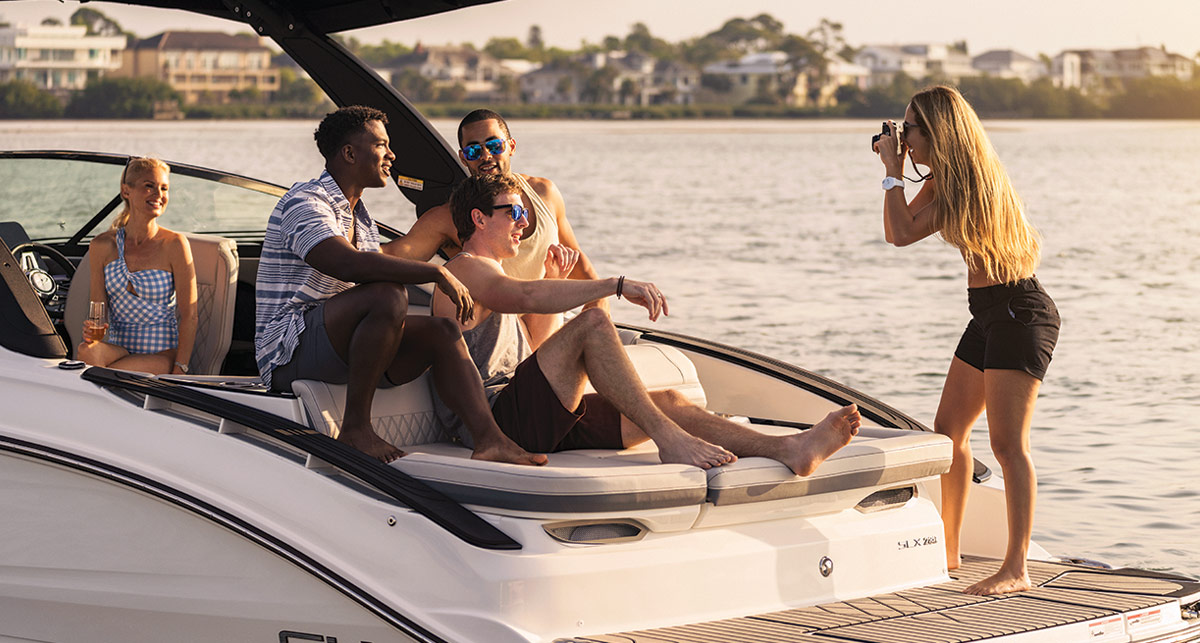 woman taking photos of multiple men and a woman on a boat