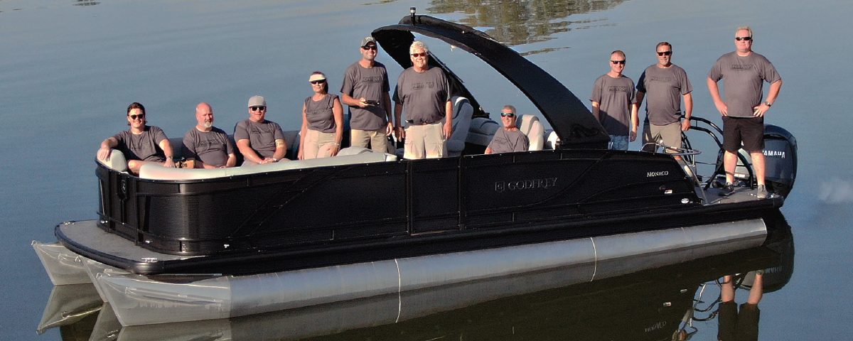 staff crew on boat smiling wearing matching gray shirts