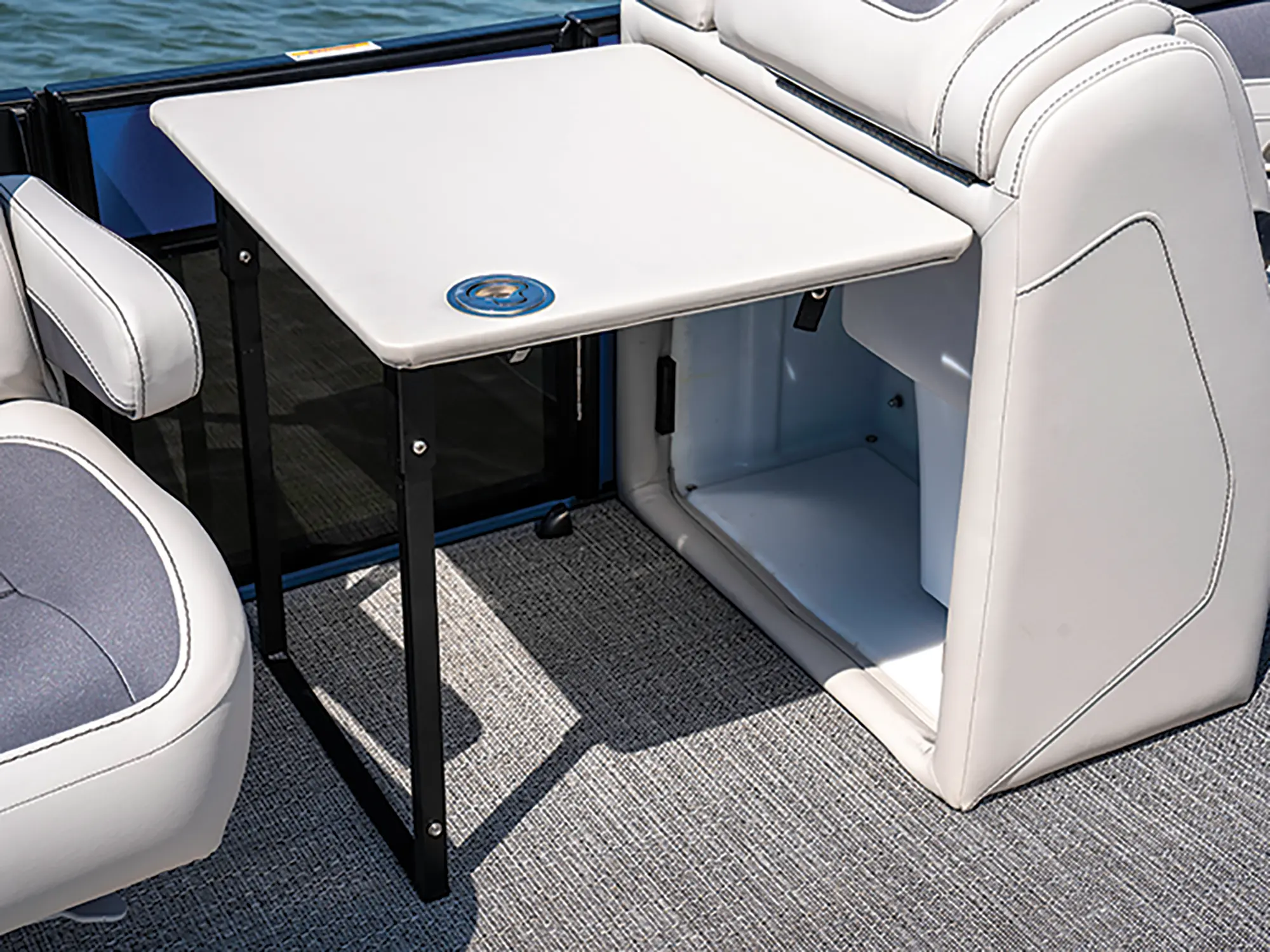 Landscape close-up photograph view of a small table sliding out deck located inside the Barletta Cabrio C22UC pontoon motorboat vehicle
