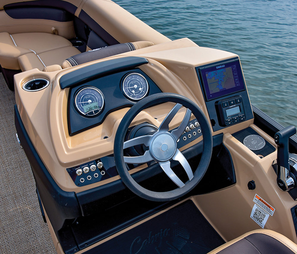 Landscape close-up angle photograph view of the Barletta Cabrio C22UC pontoon motorboat vehicle's driver side seat steering wheel, dashboard, and lever