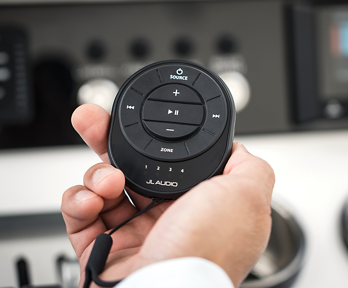 close view of a hand holding the JL Audio wireless marine audio system remote