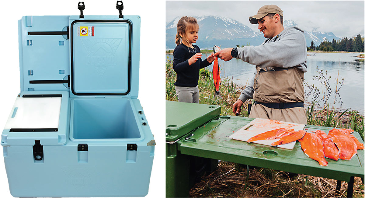 the PacBak P88-MK Cooler in blue with its top open; a man and a young girl stand at a table bedside a lake, on the table are salmon fillets