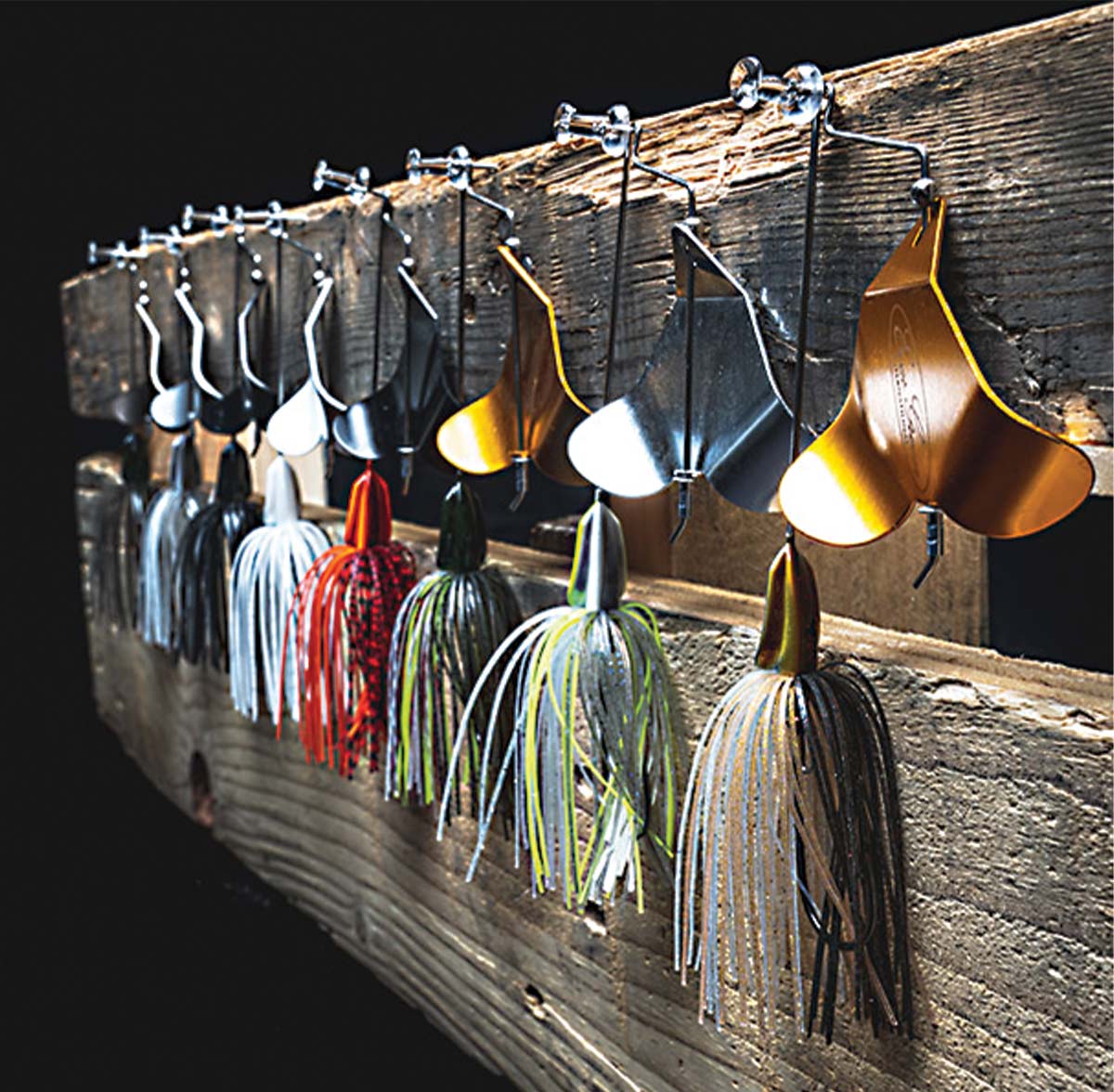 multicolored fishing lures hanging from a wood plank