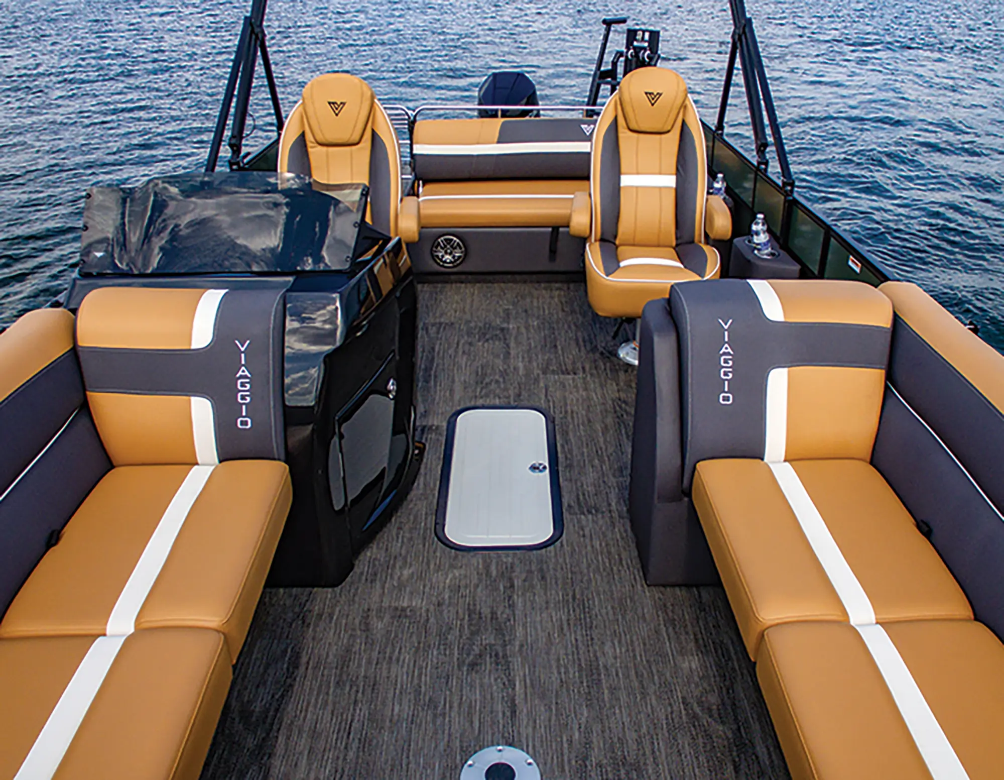 Landscape close-up top photograph view of the Viaggio Lago X24S pontoon motorboat vehicle's passenger lounge couches area, driver's seat area, and an another individual lounge chair seat next to driver's seat