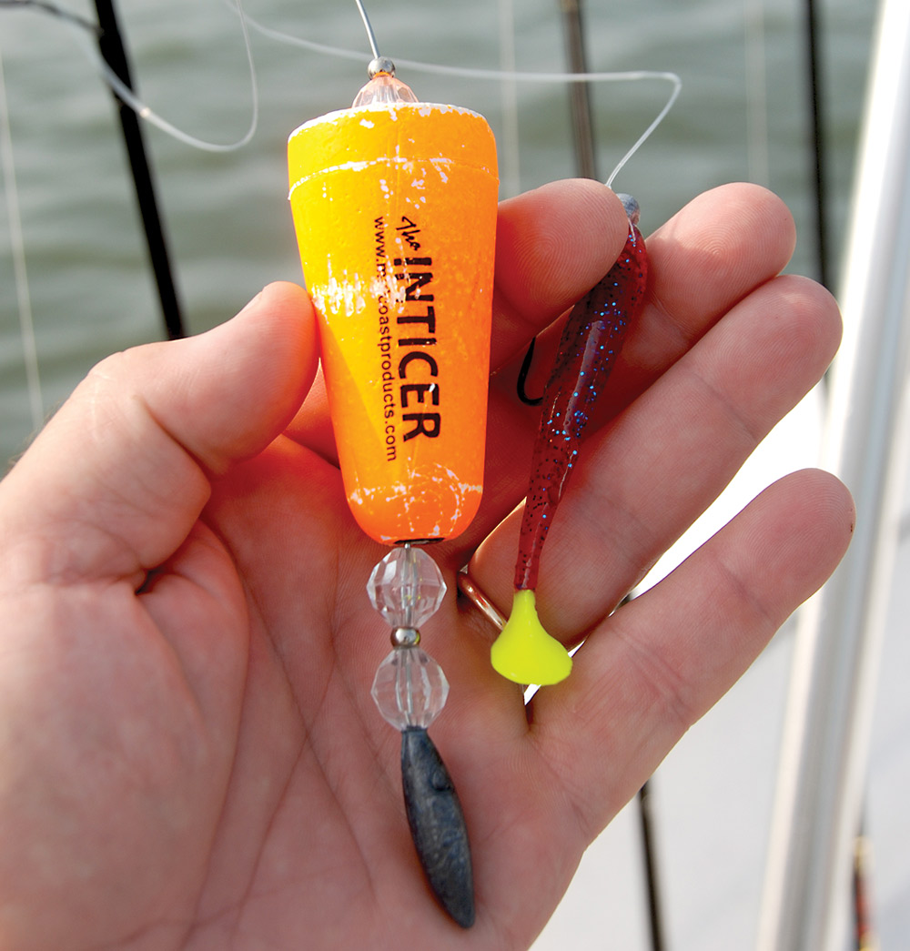 closeup of hand holding neon orange and yellow stick-style bobber