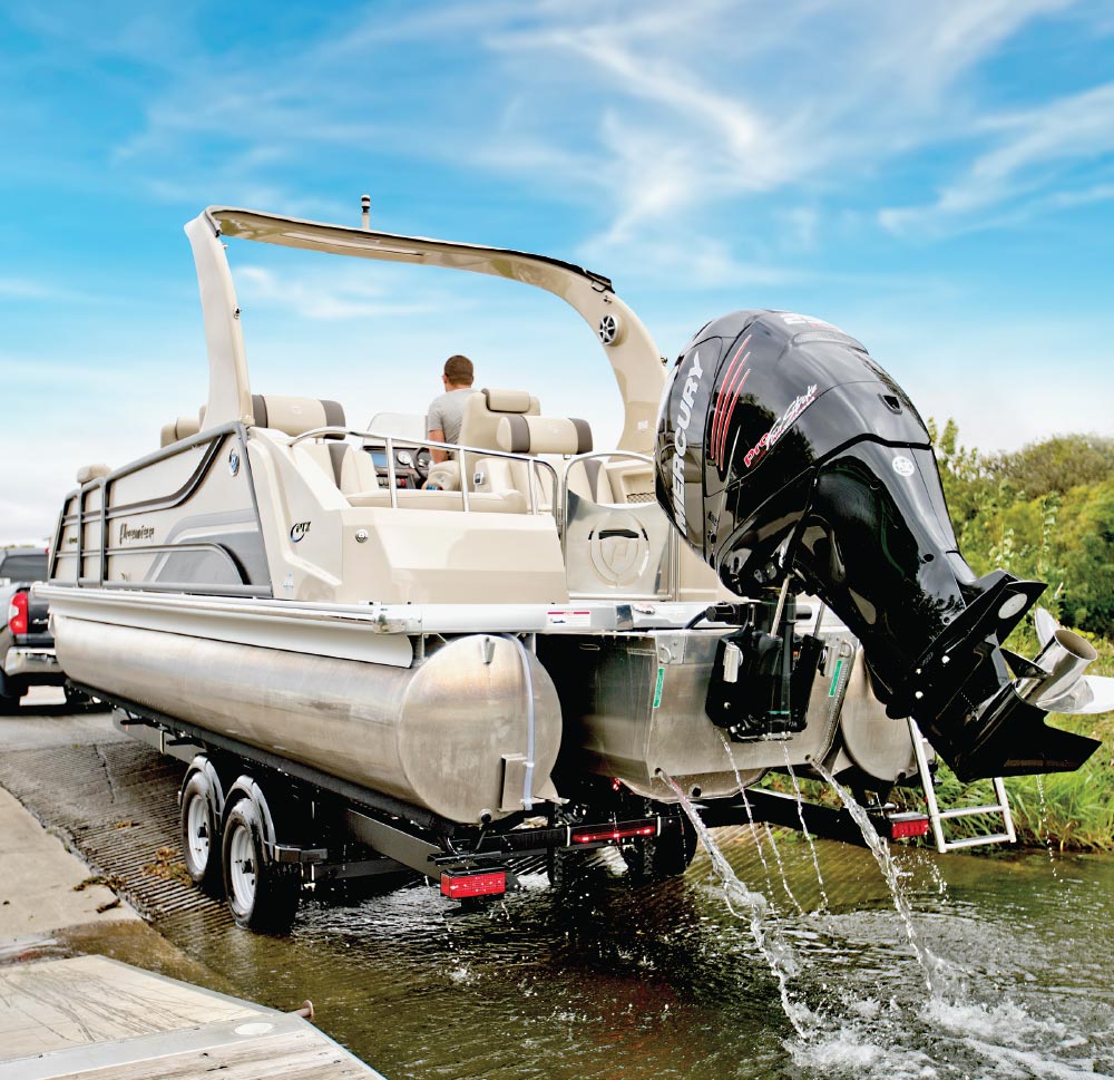 man in driver seat of ShoreLand’r Pontoon Trailer as it's being pulled out of the water