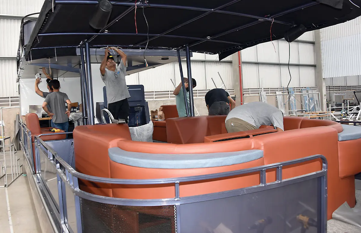 view of the helm of a muted navy blue VCAT pontoon in production in a warehouse