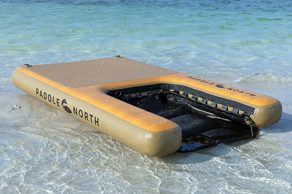 quarter view of an Up Dog inflatable doggy pad floating in shallow water