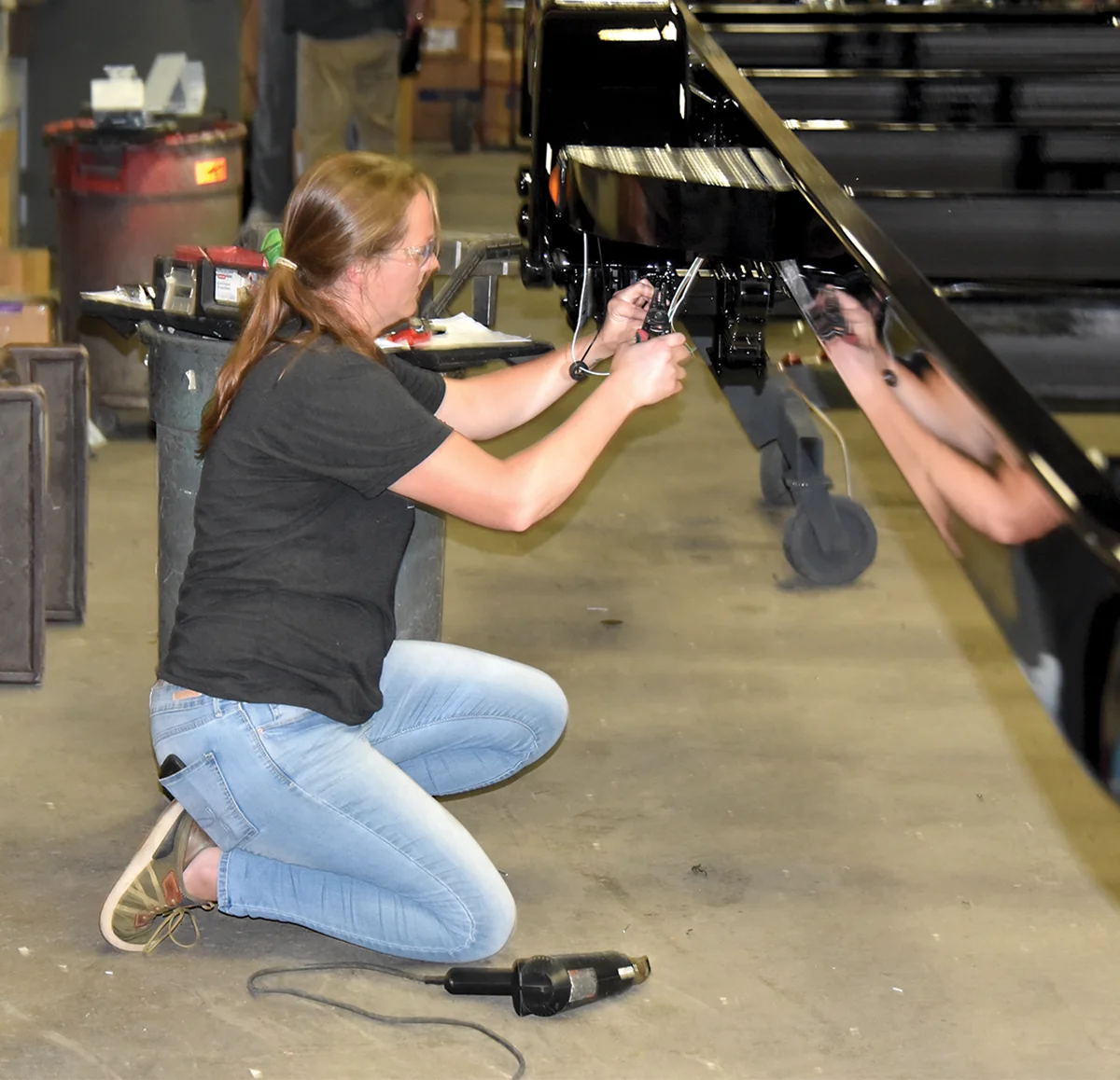 woman wearing safety goggles working on the boat trailer frame