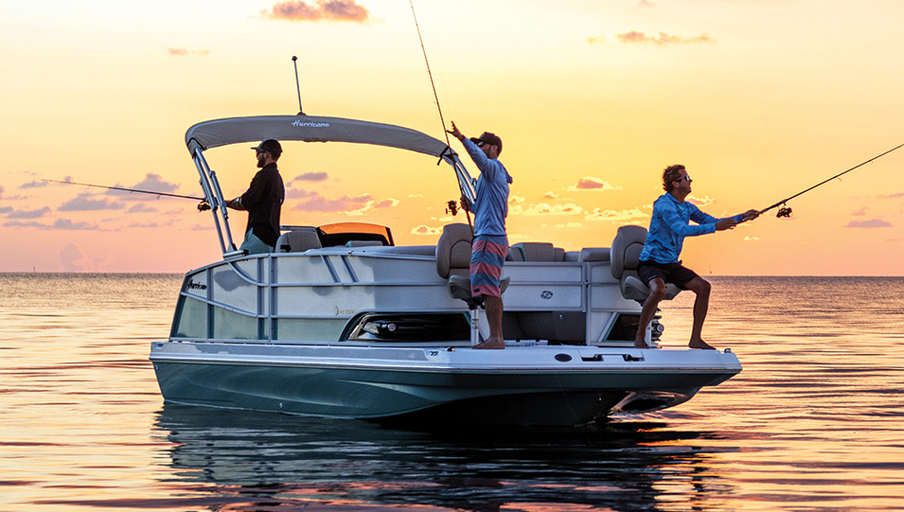 three men fishing on the Hurricane FunDeck 2360 Fish pontoon during sunset