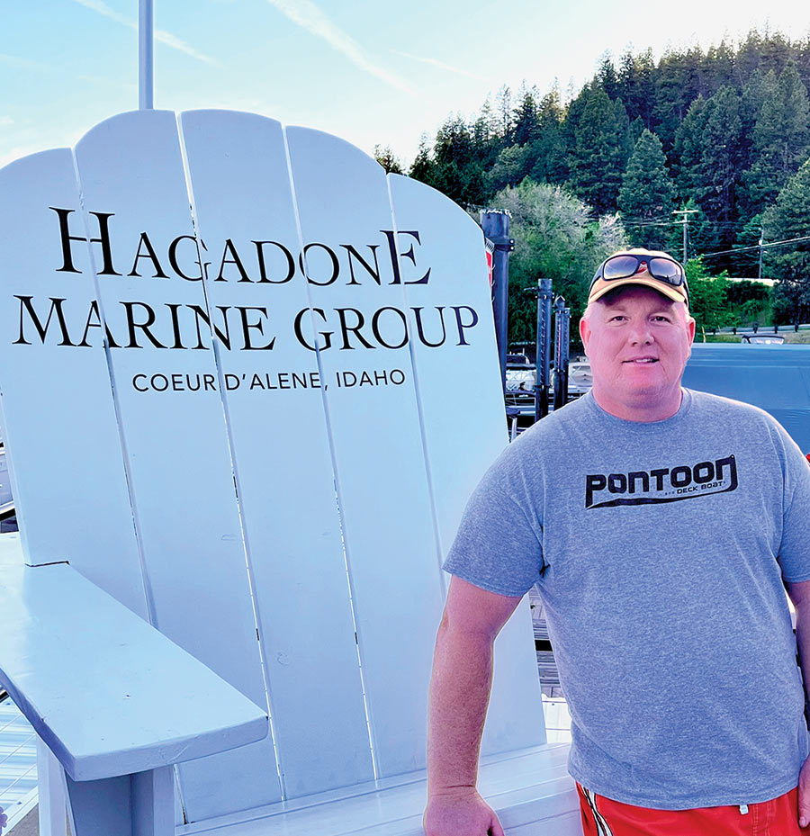 Brady L. Kay standing beside a large Hagadone Marine Group chair