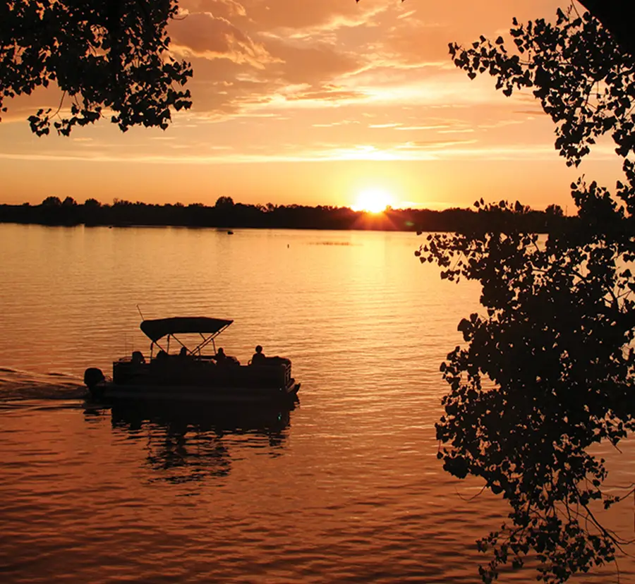 silhouette of pontoon sailing during sunset