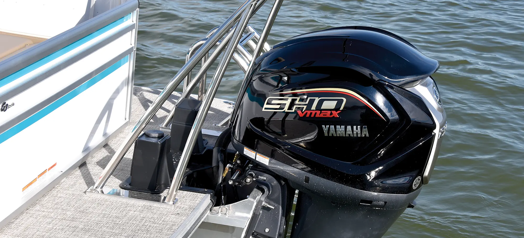Rear angle outdoor landscape photograph of the Yamaha VF250 XB V MAX SHO V6 outboard motor engine from the SunCatcher Select 324 SL pontoon motorboat vehicle