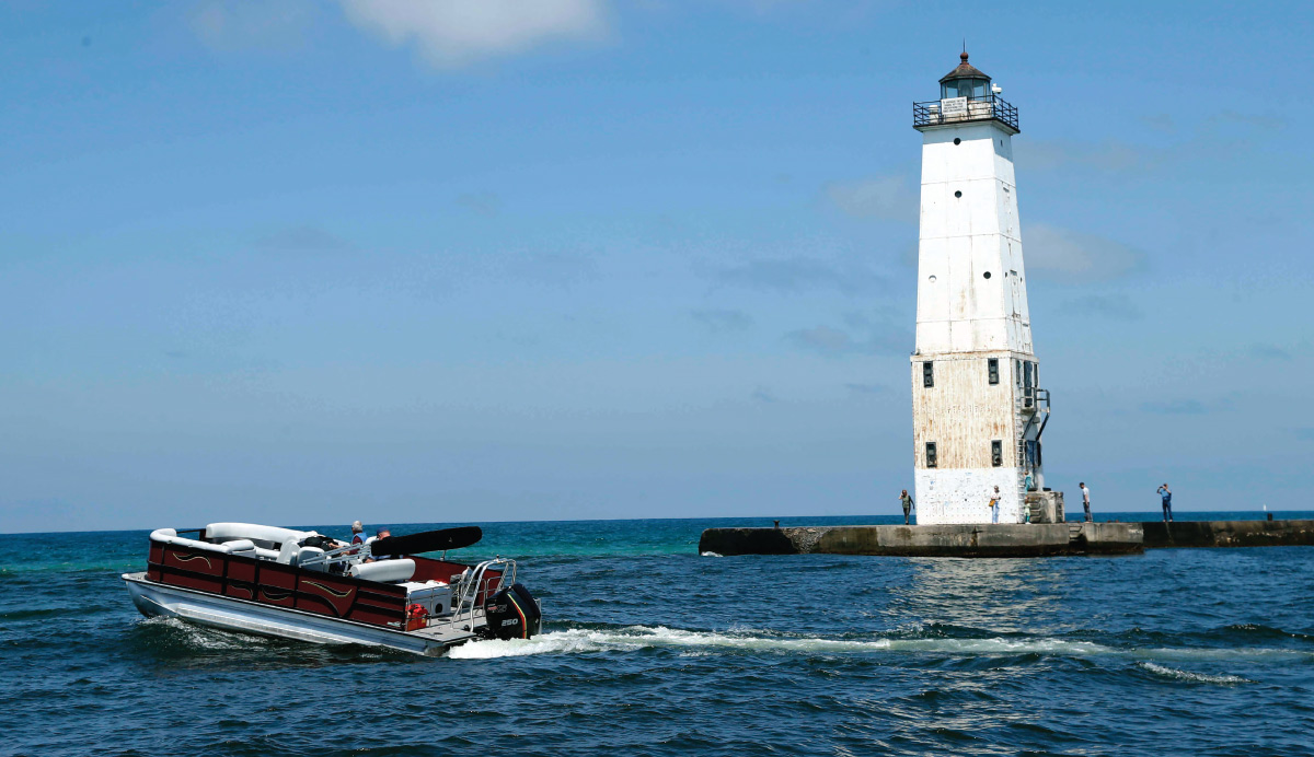Bentley Legacy 223 Navigator on water with lighthouse behind it 