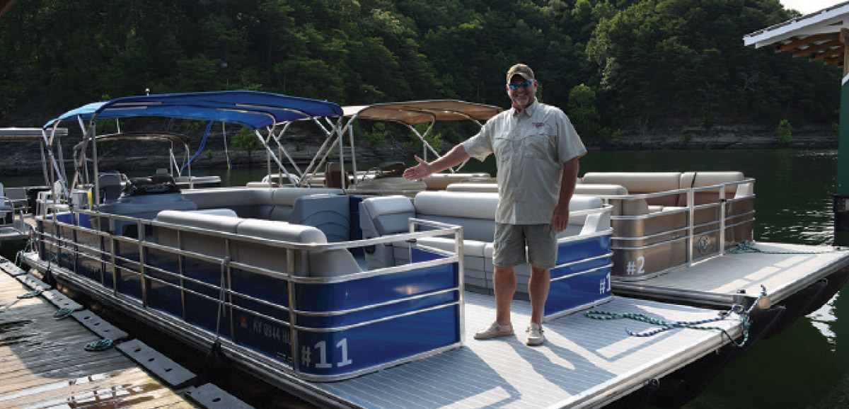 man smiling while standing next to docked boat