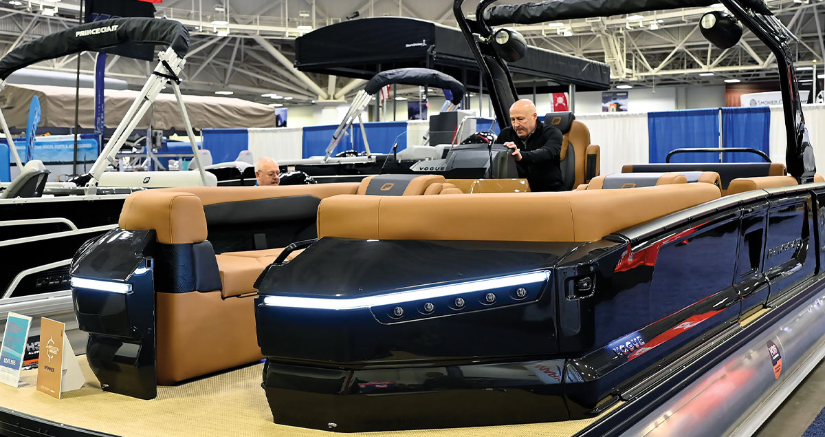 a man sits at the helm of a Princecraft Vogue 25 RL pontoon demonstrating the bow lights